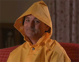 bill murray in a yellow rain jacket with the hood up saying "K"